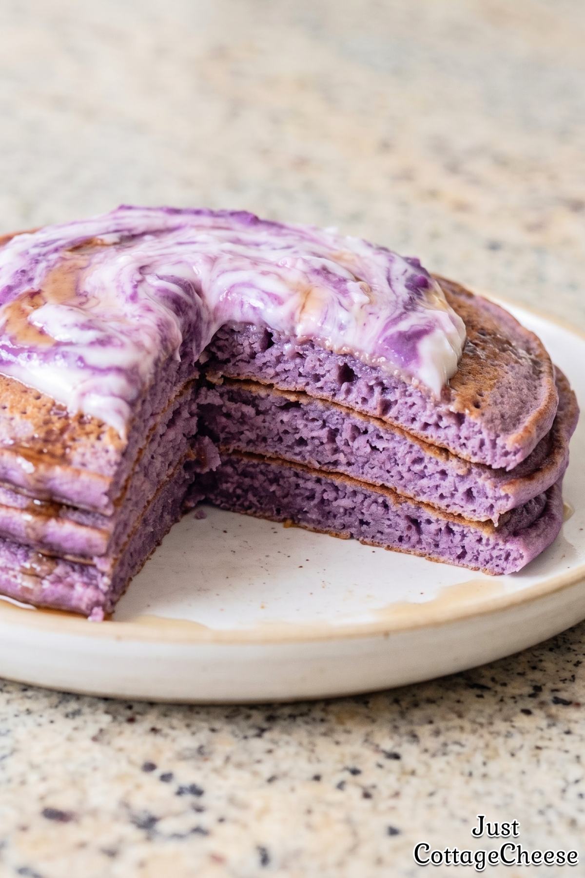 Warm stack of fluffy purple ube pancakes.